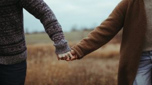 Two people holding hands in a field