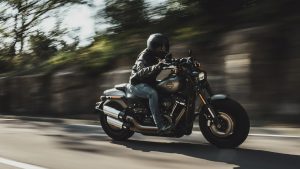 A person riding a motorcycle down a road during the day