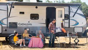 A family relaxing and grilling outside their RV