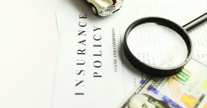 Copy of an insurance policy with a magnifying glass and $100 bill