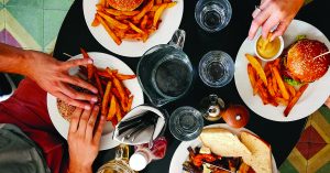 people eating burgers and fries at a restaurant