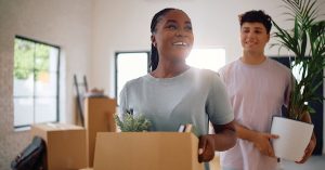 Couple reviewing a moving checklist and insurance documents while preparing to move to a new state