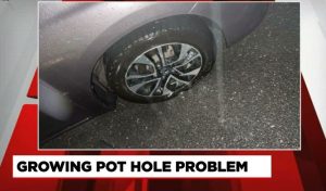 Car tire in a pothole news coverage