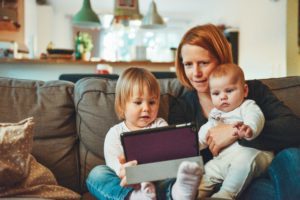 Woman looking at tablet with children