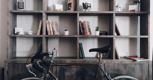 Bicycle stored next to bookshelf
