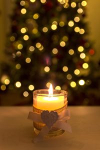 Candles lit in front of Christmas tree