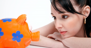 Woman looking at orange and blue piggy bank