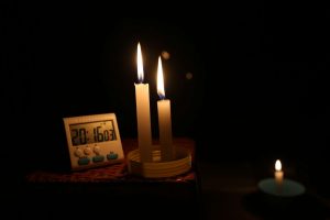 Digital clock illuminated by candlelight