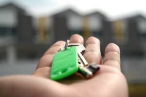 Person holding out keys with a fob