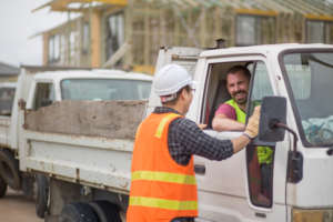 Man in a hardhat talking to worker at construction site